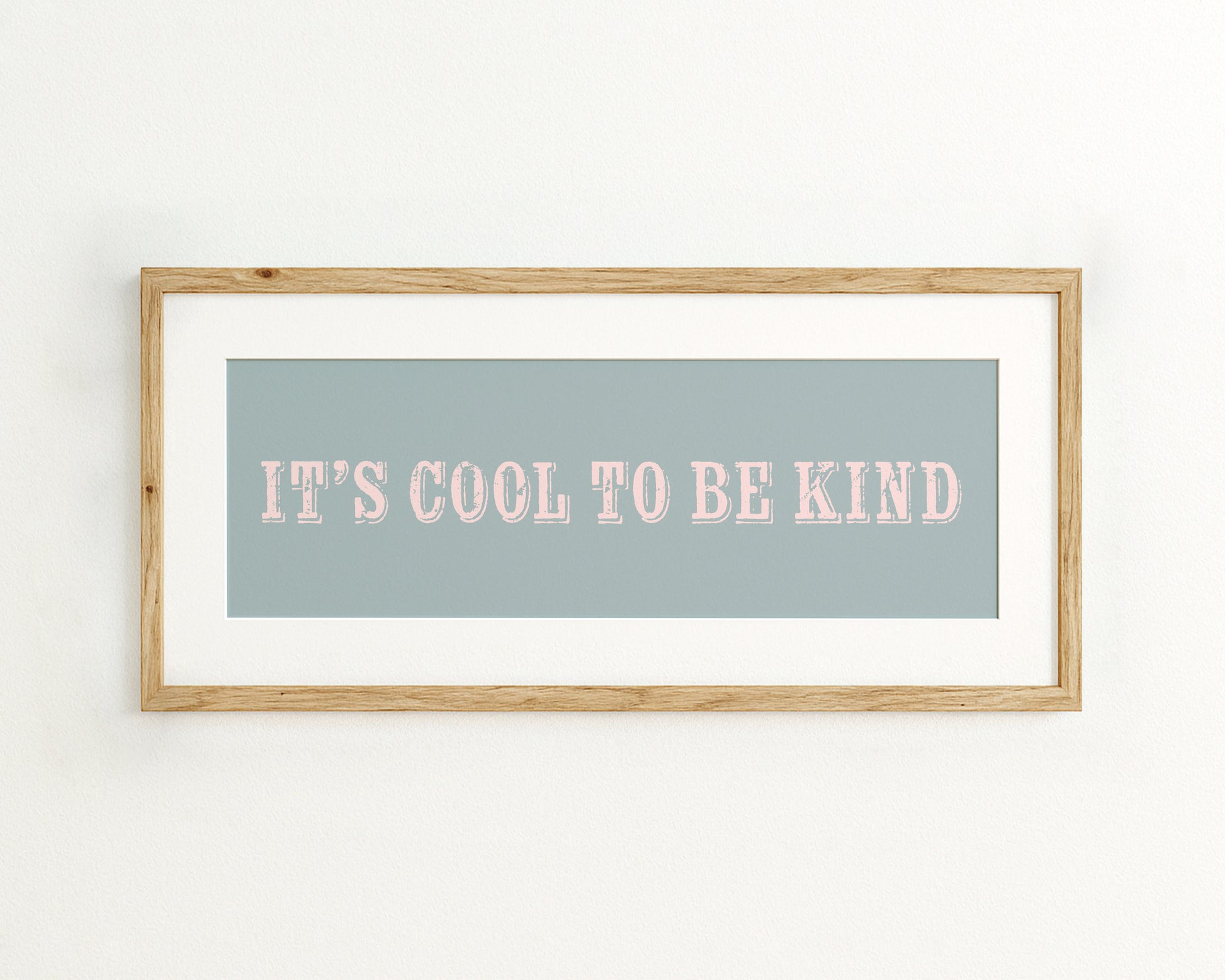 Framed print with 'It's cool to be kind' text on a light blue background