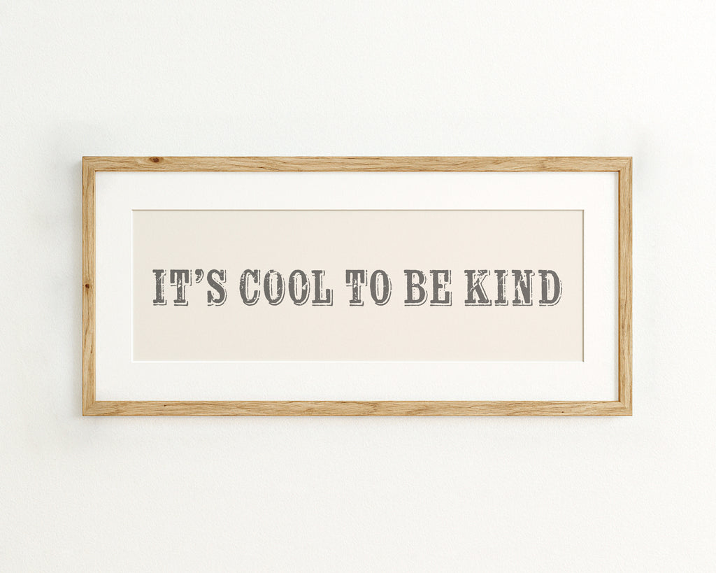 Framed print with 'It's cool to be kind' text on a cream background