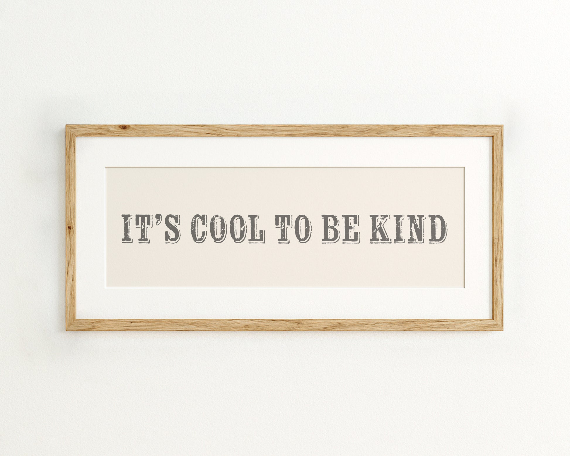 Framed print with 'It's cool to be kind' text on a cream background