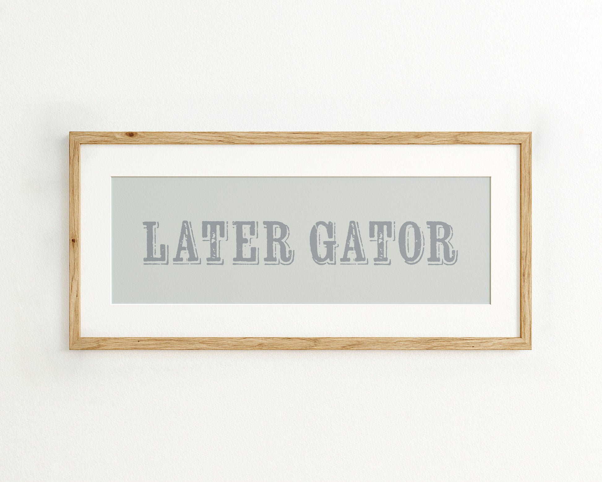Framed artwork with 'LATER GATOR' text on a light blue background