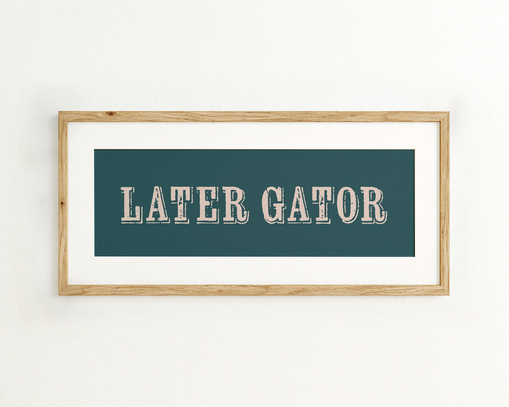 Framed artwork with 'LATER GATOR' text on a teal background