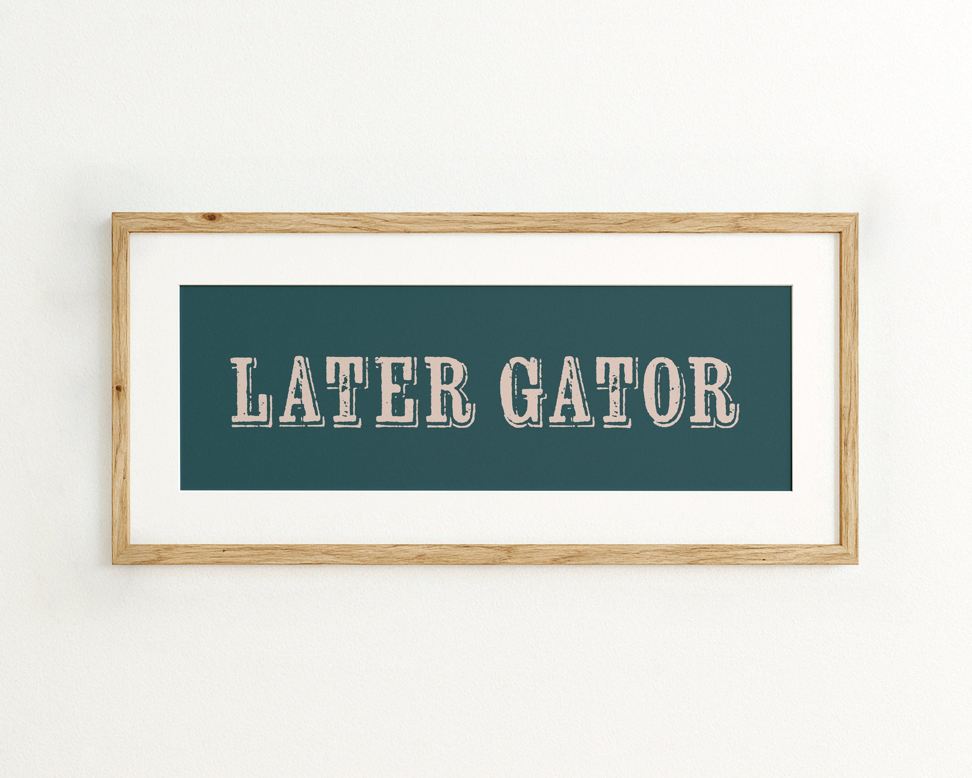 Framed artwork with 'LATER GATOR' text on a teal background