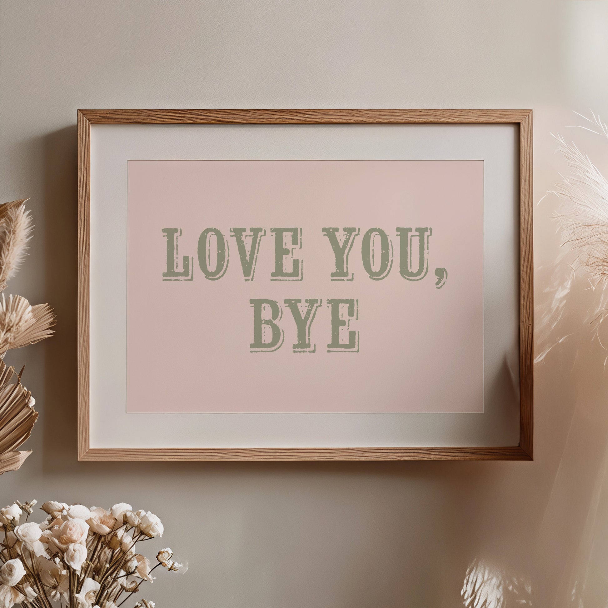 Framed artwork with 'LOVE YOU, BYE' text on a plain wall.