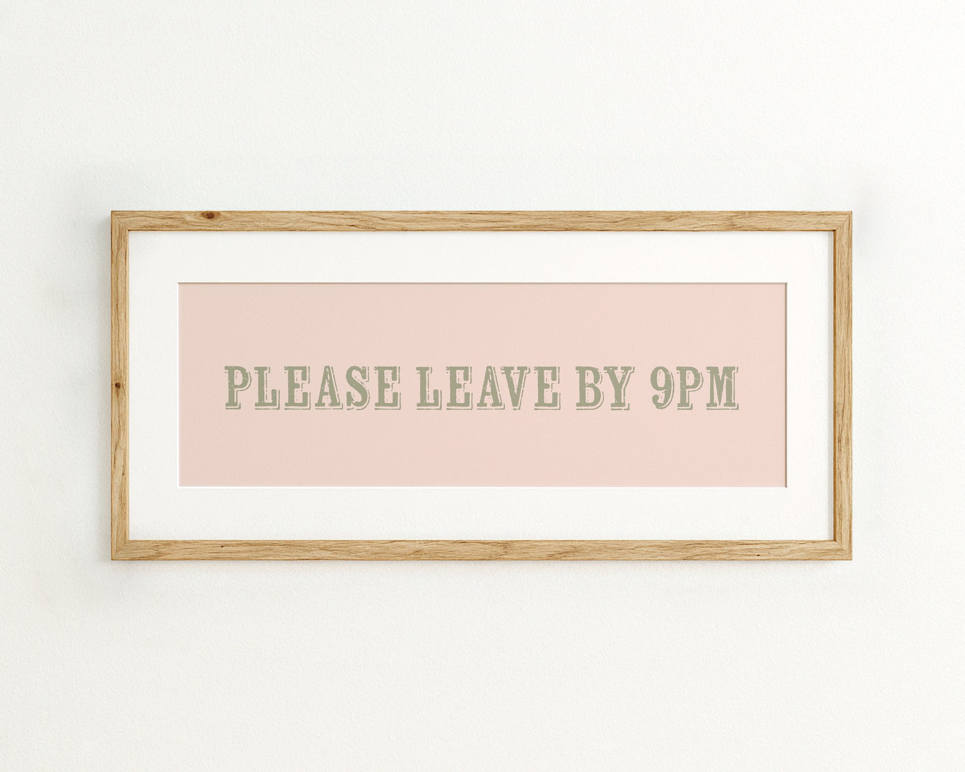 Framed sign with 'PLEASE LEAVE BY 9PM' text on a light pink background