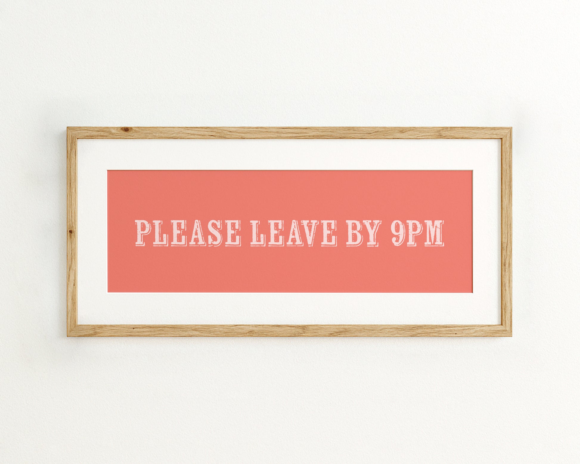 Framed poster with 'Please Leave By 9PM' text on a coral background