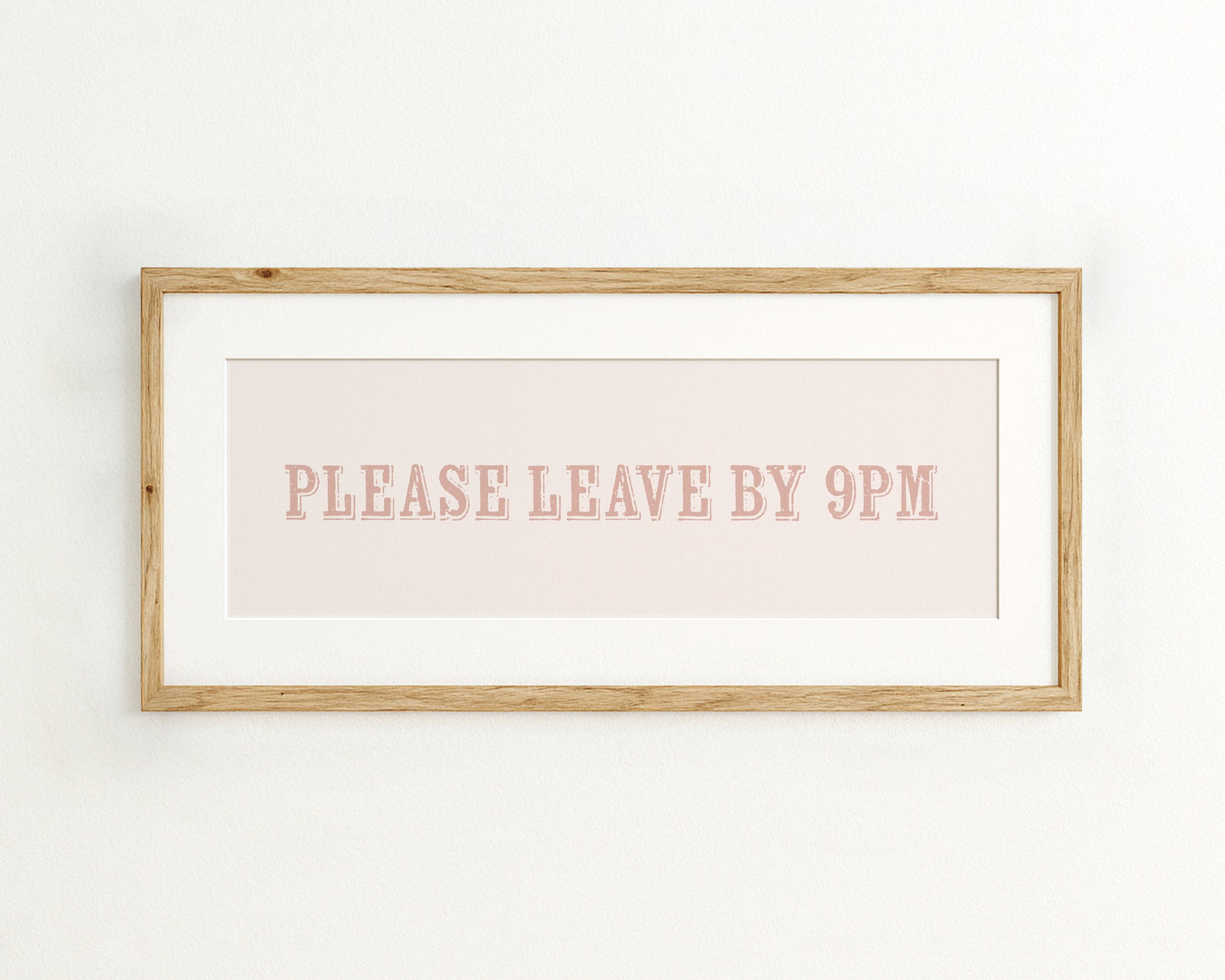 Framed artwork with text 'PLEASE LEAVE BY 9PM' on a light pinnk background
