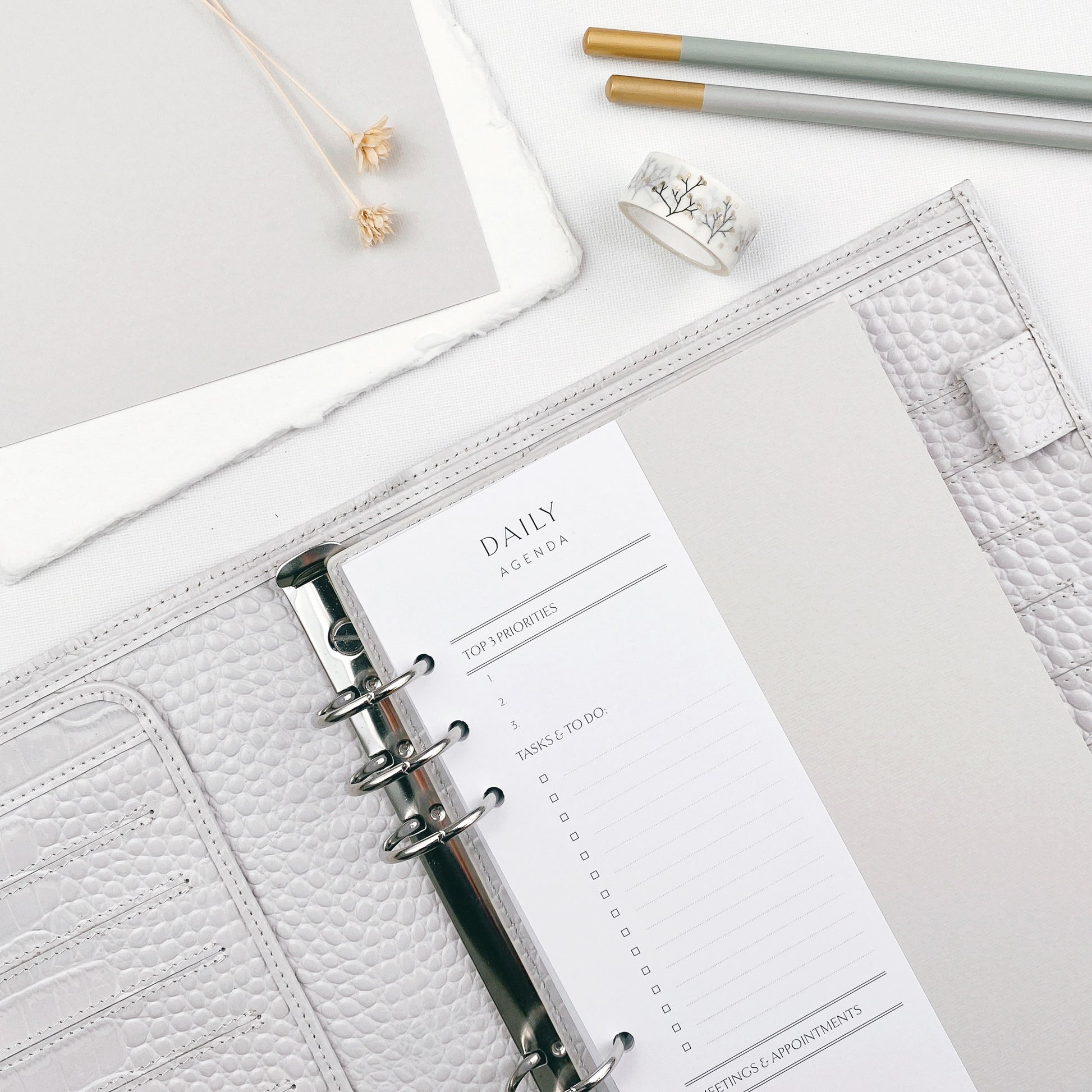 Daily agenda slimline insert with leather planner on a white surface