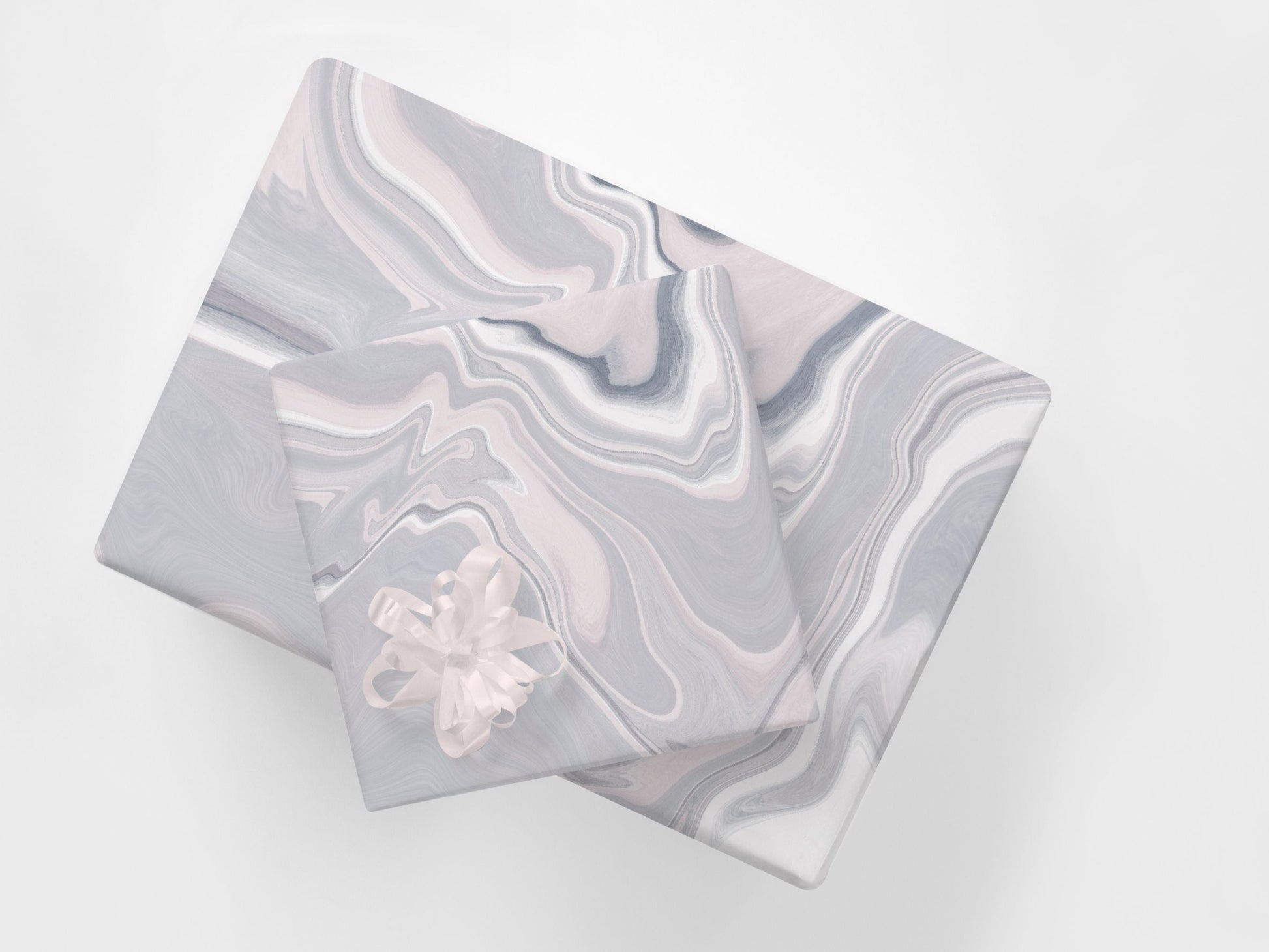 Two gift wrapped parcels featuring pink and grey abstract marble design wrapping paper