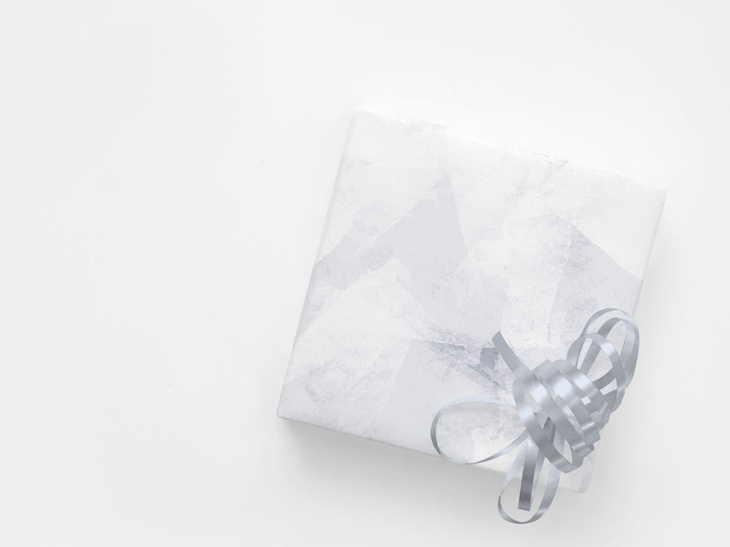 A gift wrapped in a subtle abstract paper in blue and white tones