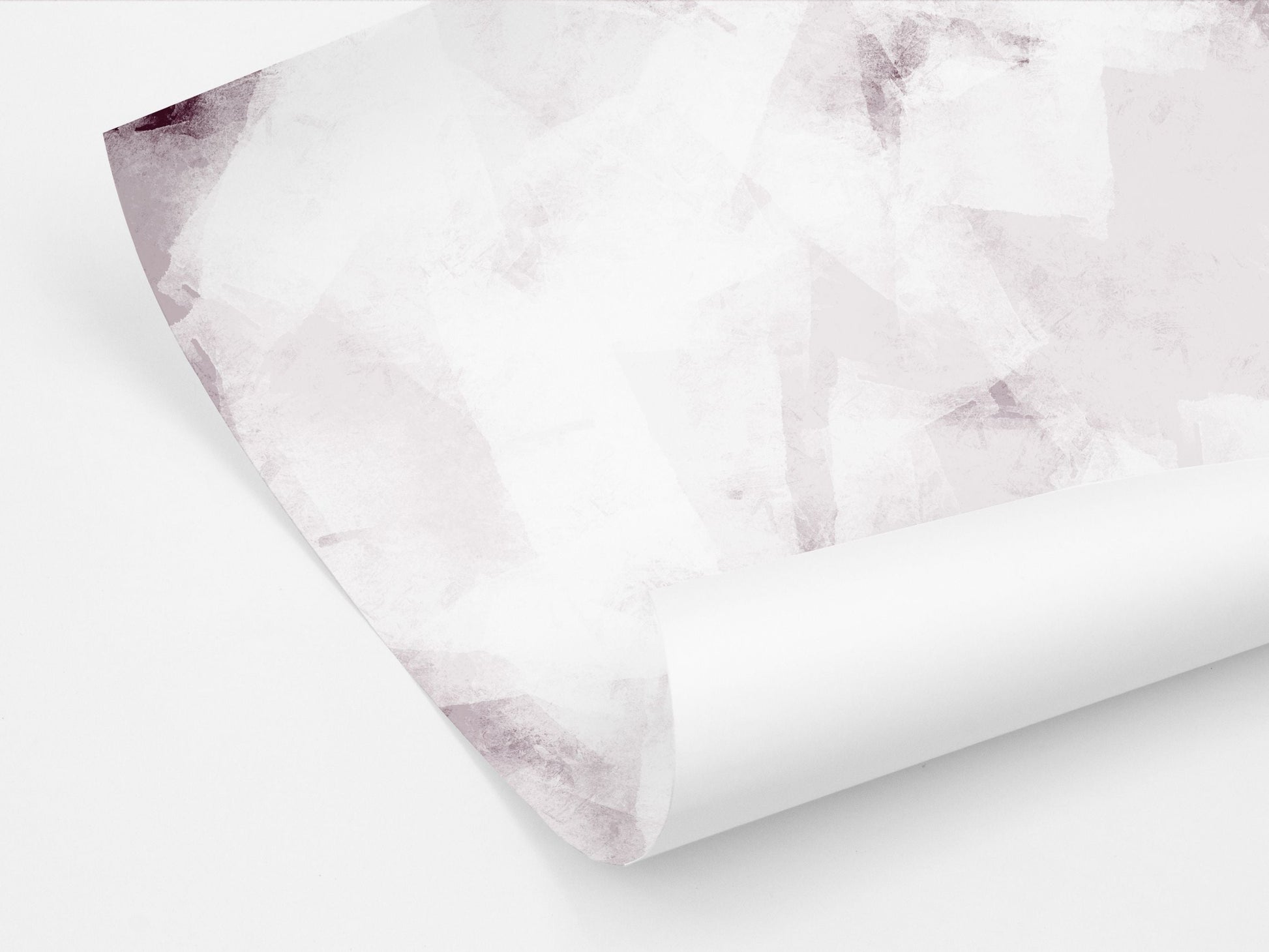 A partially unrolled sheet of wrapping paper showing an abstract design with ice pattern in pink tones